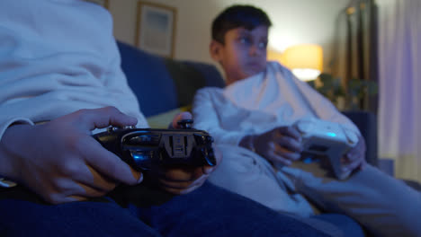 Close-Up-On-Hands-Of-Two-Young-Boys-At-Home-Playing-With-Computer-Games-Console-On-TV-Holding-Controllers-Late-At-Night-8